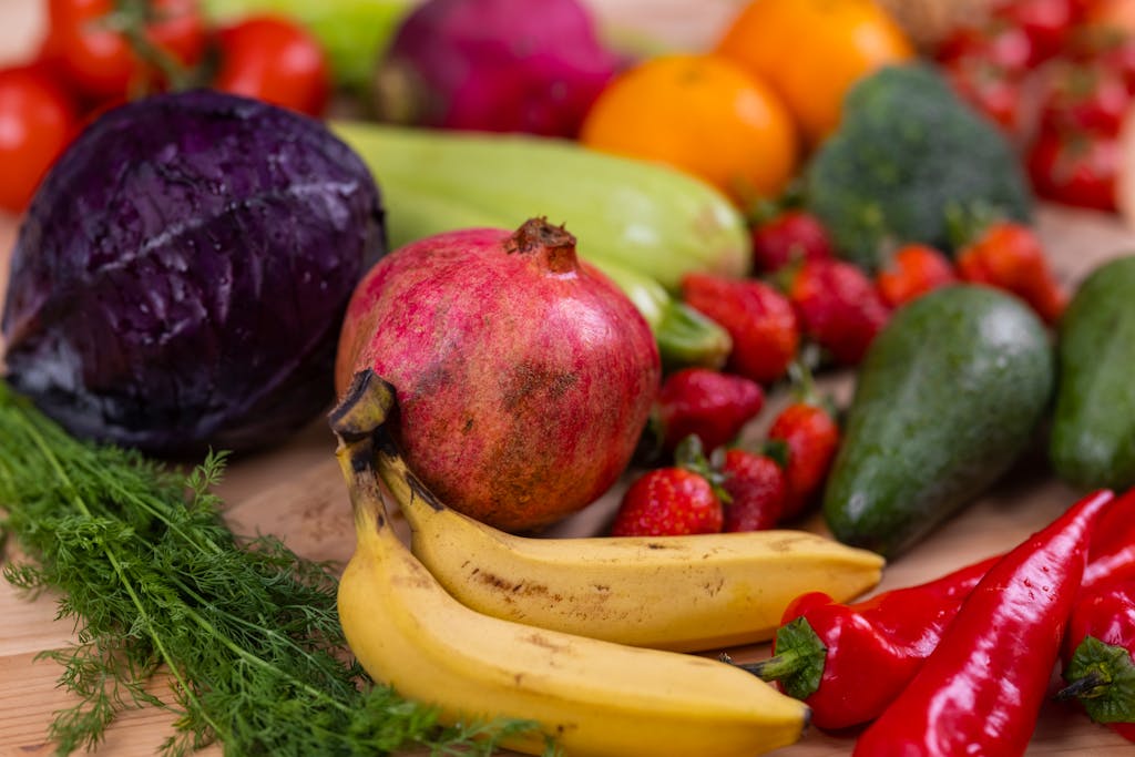 A variety of fresh fruits and vegetables arranged beautifully on a wooden table, showcasing natural nutrition.