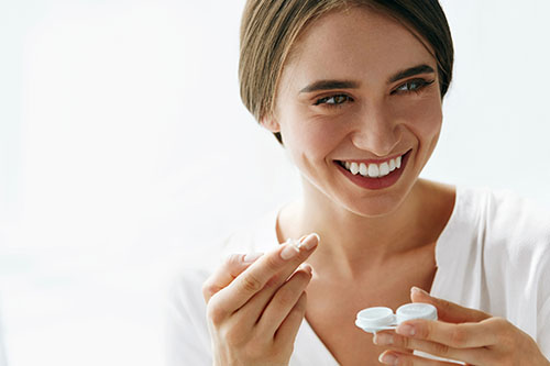 Woman putting in contact lenses